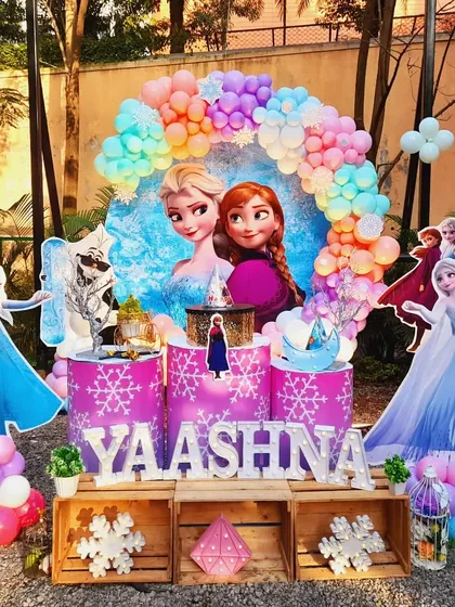 A magical Frozen theme for Yaashna's 6th birthday. This outdoor setup includes a vibrant pastel balloon arch, life-sized cutouts of Elsa and Anna, and custom-themed pedestals for the cake, all designed to transport the kids straight to Arendelle.