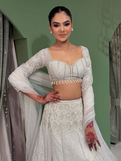 A full-length view of the white chikankari lehenga look. The makeup is kept soft and clean to let the beautiful outfit shine.