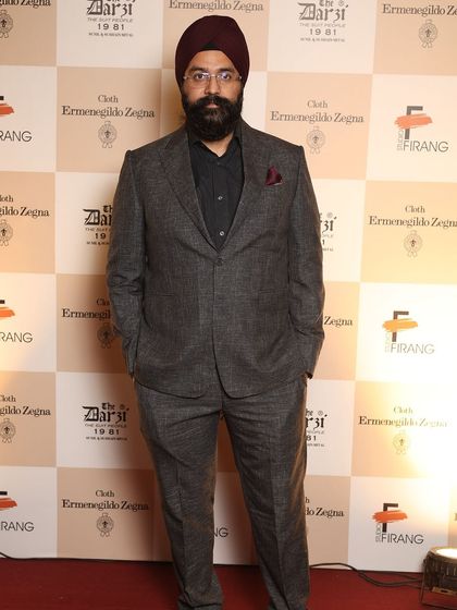 A guest dressed in a sophisticated grey tweed suit, showcasing a refined sense of style at our collaborative event with Ermenegildo Zegna.