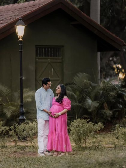 Posed in a beautiful park setting, this shot captures the couple in a moment of shared affection. The soft evening light and lush greenery provide a perfect natural backdrop for their maternity story.