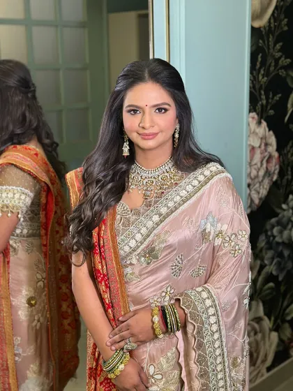 The final look of the client with her soft half-updo, looking elegant in a beautiful saree.