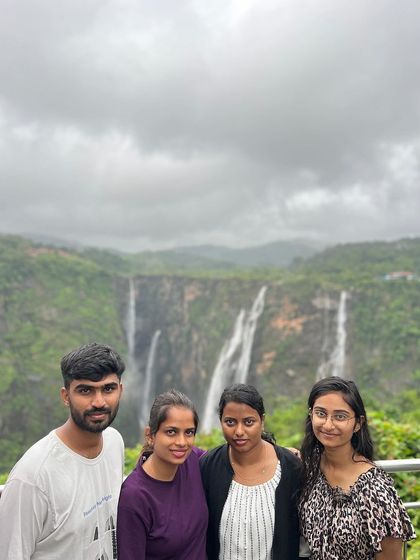 A group posing in front of the majestic Jog Falls.