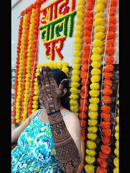 A festive shot of a guest's mehndi at a "Shaadi Wala Ghar" (wedding house).