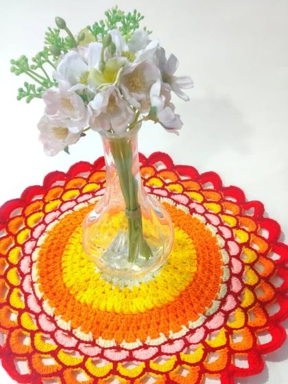 My most loved colorful crochet doily, shown here as a beautiful base for a flower vase. It demonstrates how versatile these pieces can be.