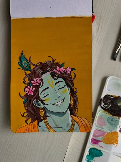 A top down view of the finished Krishna painting, highlighting the joyful expression and the peacock feather.