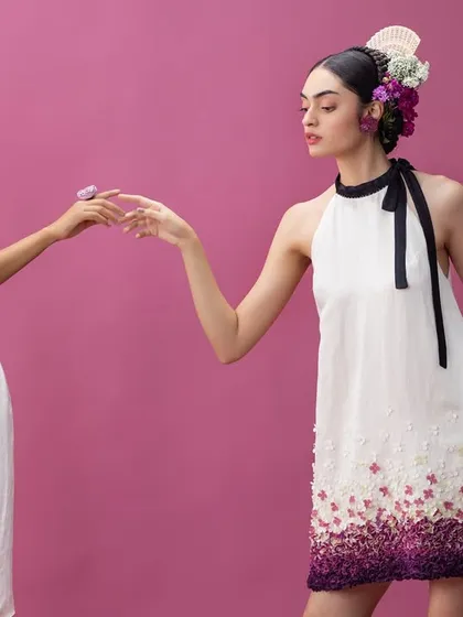 A dual-model shot from a floral-themed editorial, showcasing harmonious styling. I dressed both models in complementary white dresses with purple gradient details and matching floral headpieces to create a story of mirrored elegance and shared femininity.