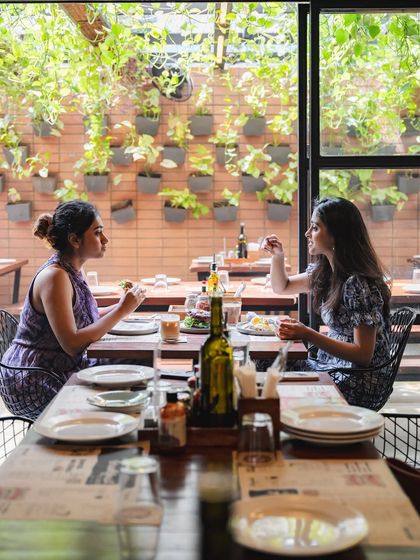 Two customers dining in our Indiranagar outlet, with its beautiful green wall creating a garden-like feel.