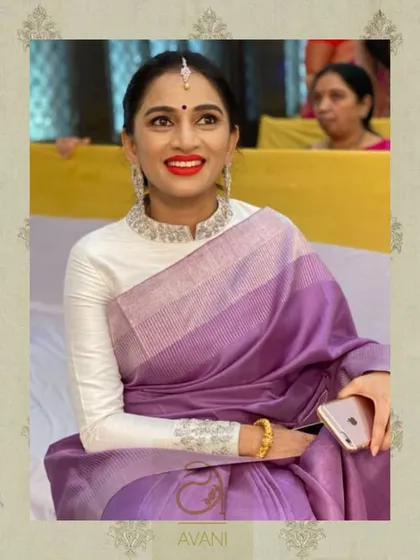 A modern, high-neck blouse in pure white with full sleeves. The cuffs are adorned with delicate silver embroidery, adding a touch of elegance to this minimalist design.