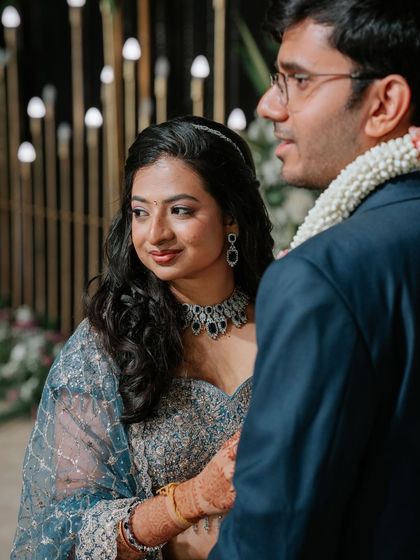 A beautiful candid moment between the couple at their reception. The bride's makeup is subtle and elegant, with a soft shimmer on the eyes that catches the light beautifully.