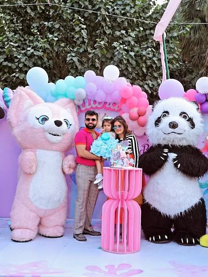 A fun family portrait from an outdoor birthday party. The celebration included character mascots like Mickey, Minnie, and a panda, creating a vibrant and exciting atmosphere for the kids.