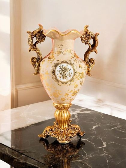 A classic Victorian vase with ornate handles and a flared rim, decorated with delicate gold floral motifs. It's an ideal vessel for a lush bouquet of flowers or as a standalone decorative object.
