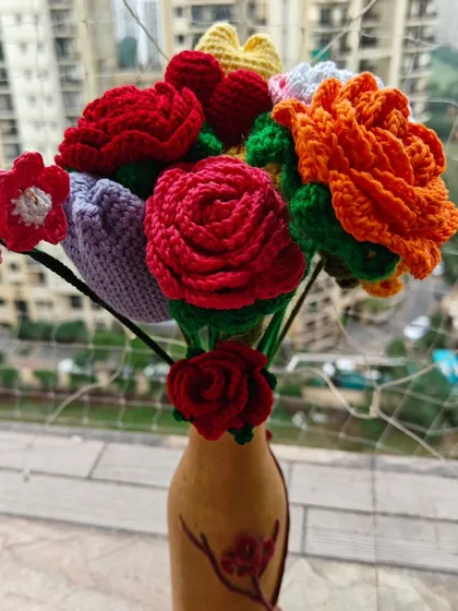 Another angle of my colorful crochet bouquet, highlighting the detailed craftsmanship of the red and orange roses and the delicate purple tulip.