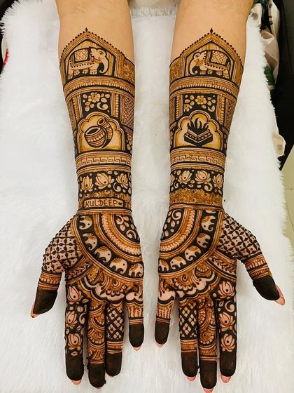 This design is rich with auspicious symbols for a new beginning. It includes a kalash (pot), a sacred book, and elephants, all woven into a beautiful pattern with the bride's name, Kuldeep.