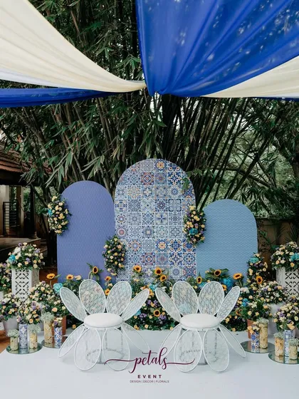 Pre-wedding events are a chance to be playful and creative. For this Haldi, I designed a unique Mediterranean theme with vibrant blue tiles, sunny yellow florals, and whimsical flower-shaped chairs, transporting guests to a coastal paradise.
