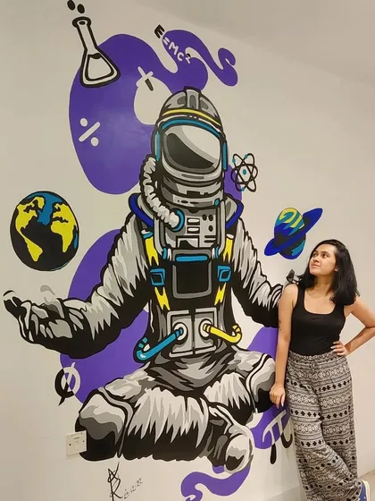 Here I am with the final astronaut mural for a teaching institute in Mumbai. The goal was to make the space more inspiring for students, and this 8x7 feet cosmic design, complete with planets and science symbols, did just that.