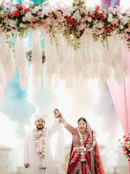 A moment of pure celebration at the mandap. The bride's makeup is vibrant and joyful, perfectly capturing the energy of this happy moment.