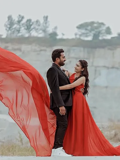 The vibrant red of this gown creates a powerful contrast with the natural, earthy tones of the quarry. The lightweight train flows effortlessly, adding a touch of elegance to this pre-wedding couple's portrait.