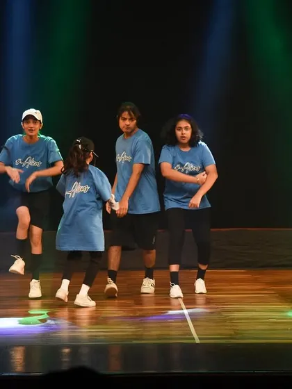 Dancers are captured mid-step during a dynamic hip-hop routine. This action shot highlights the athletic and intricate footwork we teach in our classes.