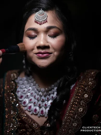 A close-up shot capturing the final touches of the bride's makeup, a quiet moment of preparation.