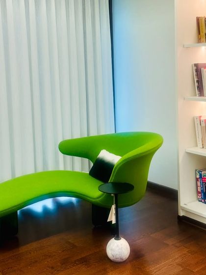Another angle of the serene reading nook, showing how the soft, sheer curtains diffuse natural light, creating a peaceful ambiance next to the well-lit, built-in bookshelf.