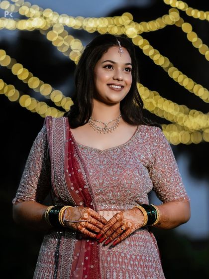 My bride Mrudhula looking radiant against a backdrop of fairy lights for her reception. Her look is natural and subtle, letting her happiness be the main focus.
