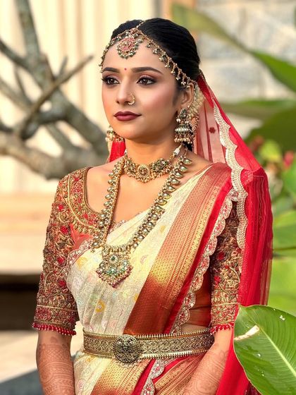 This bride is wearing a classic red and white Kanjeevaram saree. I created a corresponding makeup look with a bold red lip and defined eyes for a timeless bridal appearance.