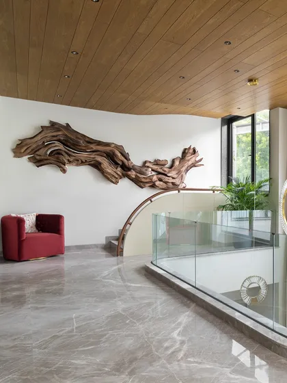 A dramatic driftwood sculpture serves as a powerful art installation in this double-height stairwell. We love incorporating large-scale, organic pieces to create a strong connection with nature and add a unique focal point.