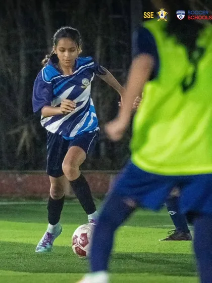 A focused Nizh Kapadia maneuvering through opponents during a training drill. These sessions are designed to simulate match pressure and improve ball control.