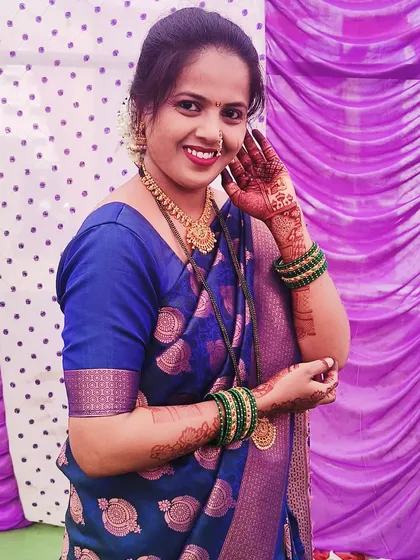 A happy client in a beautiful blue saree, her hands decorated with my henna designs for a family function.