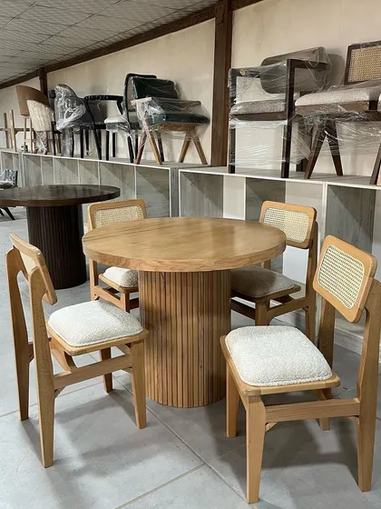 A four-seater dining set, fresh from my workshop. This set includes a round dining table with a fluted pedestal base and matching chairs with cane backrests, all made from natural-finish teak. It's a perfect example of a compact, stylish dining solution.