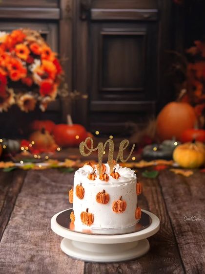 The perfect autumn cake for a first birthday. This pumpkin-themed cake was the centerpiece of a beautiful fall cake smash session, ready for a little one to enjoy.