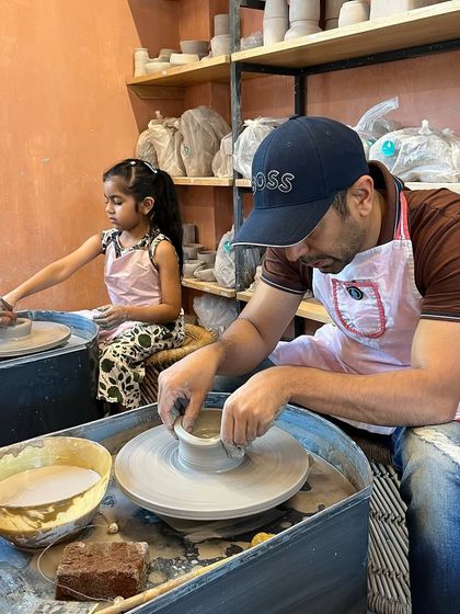 Another wonderful father-daughter pair enjoying the potter's wheel. We make sure everyone, no matter their experience level, can create something they are proud of.