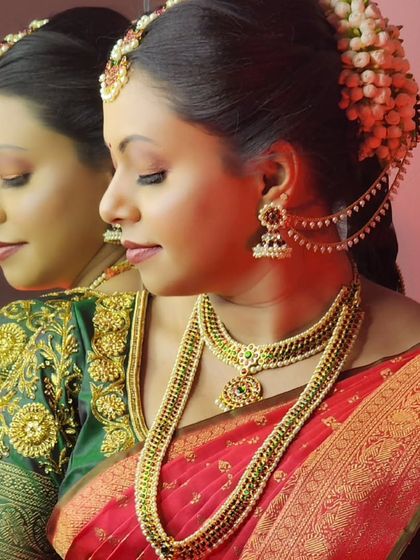 A beautiful shot of a bride looking at her reflection, wearing a traditional temple jewellery set with a pearl haram.