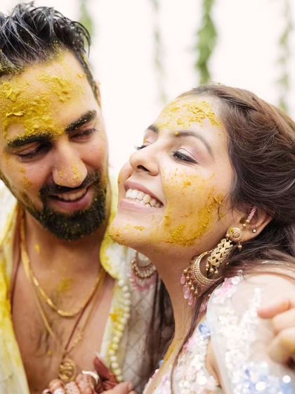 A sweet, romantic moment amidst the Haldi fun. Her makeup still looks fresh and glowing.