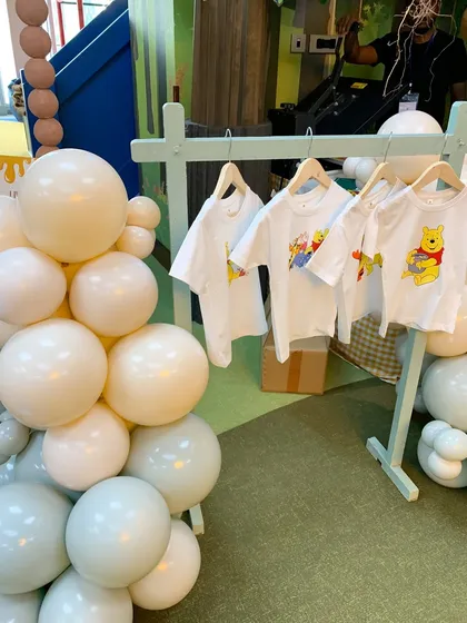 A rack of custom-printed Winnie the Pooh t-shirts, a wonderful party favor for the little guests.