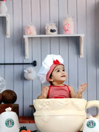 This little chef is having a blast, sitting inside a giant teacup in our detailed miniature kitchen set.