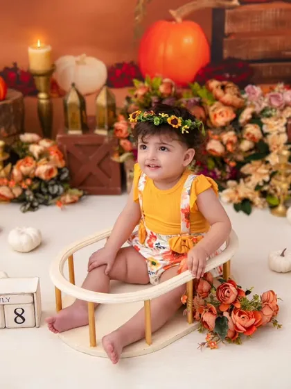 A one-year-old in her pumpkin patch. The date block and floral crown are perfect accessories for this seasonal milestone shoot.