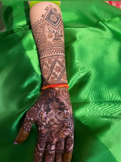 A side view of the arm, showing the detailed cuff work that complements the main Ganesh design on the palm.