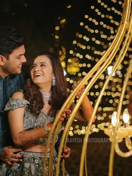 A magical sangeet night portrait, with the couple framed by golden lights and intricate decor.