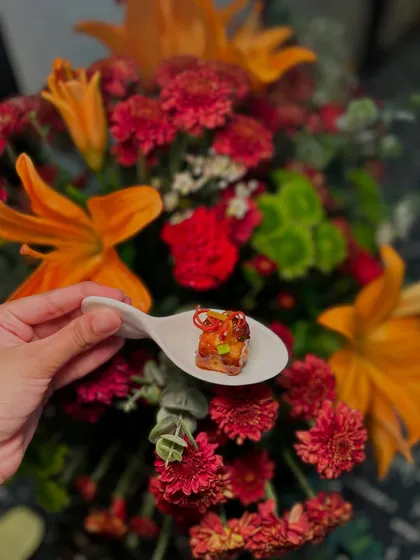 A single, perfect bite of an Asian-style cottage cheese appetizer, served on a ceramic spoon.