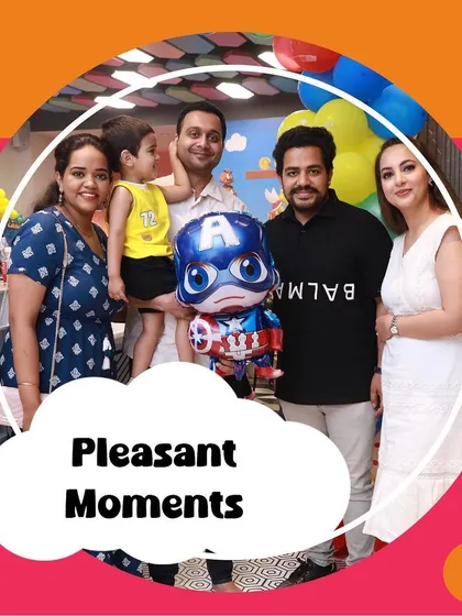 Pleasant moments captured at a party. A family poses together, holding their little one and a Captain America balloon.