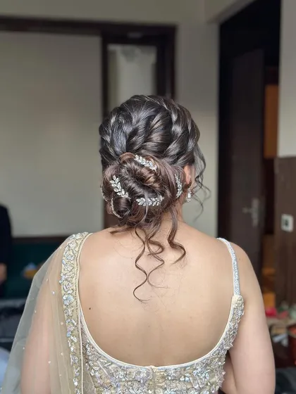 A side view of the messy bun with silver leaf accessories, showing how the tendrils frame the face.