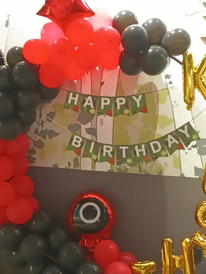 A close-up of the Squid Game theme balloon ring with custom banner and foil balloons.