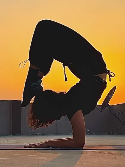 This is a moment of pure focus and strength, holding a scorpion pose against the setting sun. Achieving advanced postures like this is a journey of patience and consistent practice, something we work on every day.