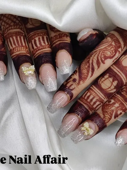 This is a beautiful example of my Indian bridal nail art. The design features a silver glitter fade on square extensions, accented with tiny butterfly charms, created to perfectly complement the intricate mehndi.