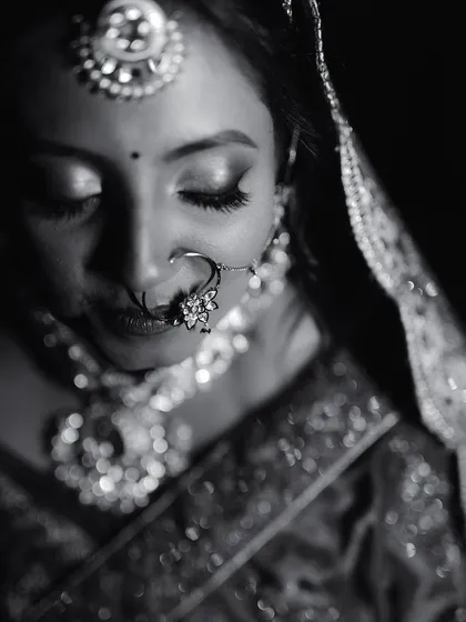 The quiet moments before the ceremony are pure poetry. We used dramatic lighting to create this timeless black and white portrait, highlighting the intricate details of the bride's jewelry and the serene expression on her face.