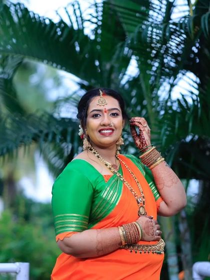 Chandana looking absolutely radiant for her baby shower. The vibrant orange and green saree is perfectly complemented by fresh makeup and traditional gold jewelry.