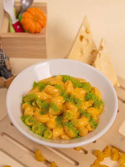 The creamiest, cheesiest Mac and Cheese, a dish that's always a winner. We give it a fun twist with a sprinkle of green herb dust.