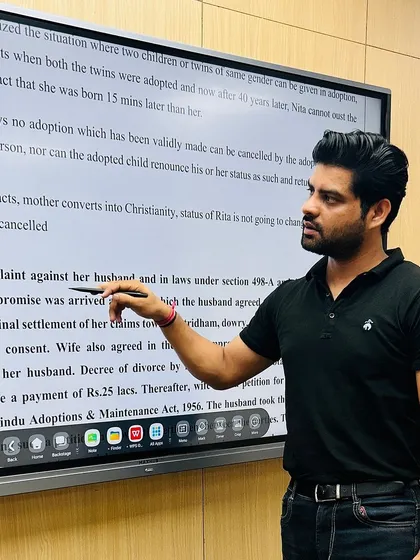 In the classroom, my focus is on clarity. Here, I am using the smartboard to dissect a case involving the Hindu Adoptions & Maintenance Act, pointing out the specifics of how a compromise was reached under Section 498-A.