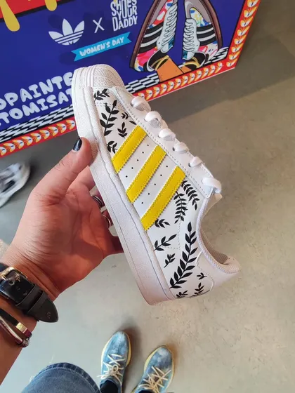 A shot from the Adidas store in Delhi, showing a pair of Superstars I custom painted with a minimal leaf pattern during a live event.